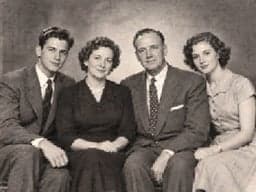 Fictional black-and-white family studio portrait in 1950s-style clothing